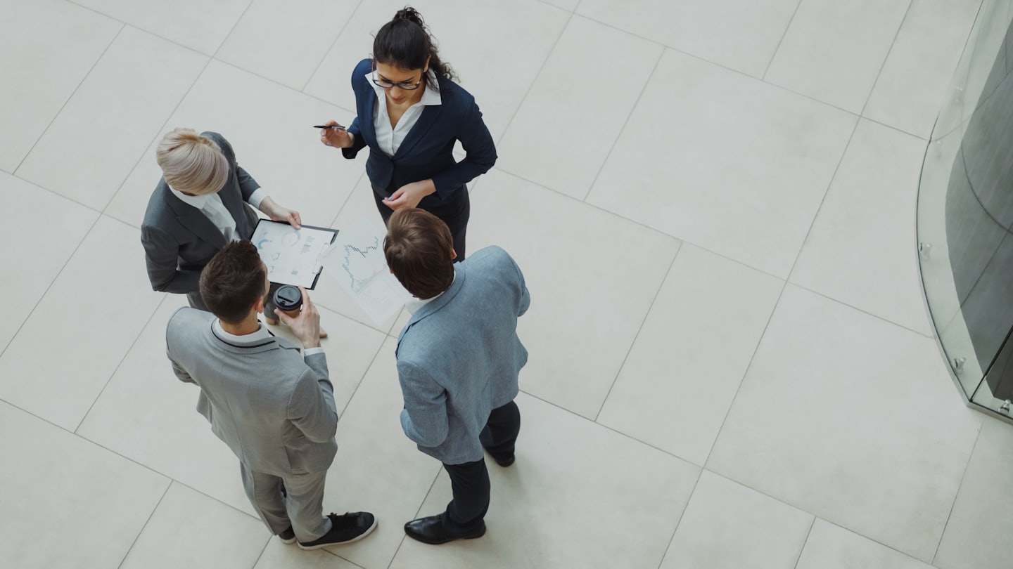 Professionisti aziendali che collaborano su grafici in un ufficio moderno.