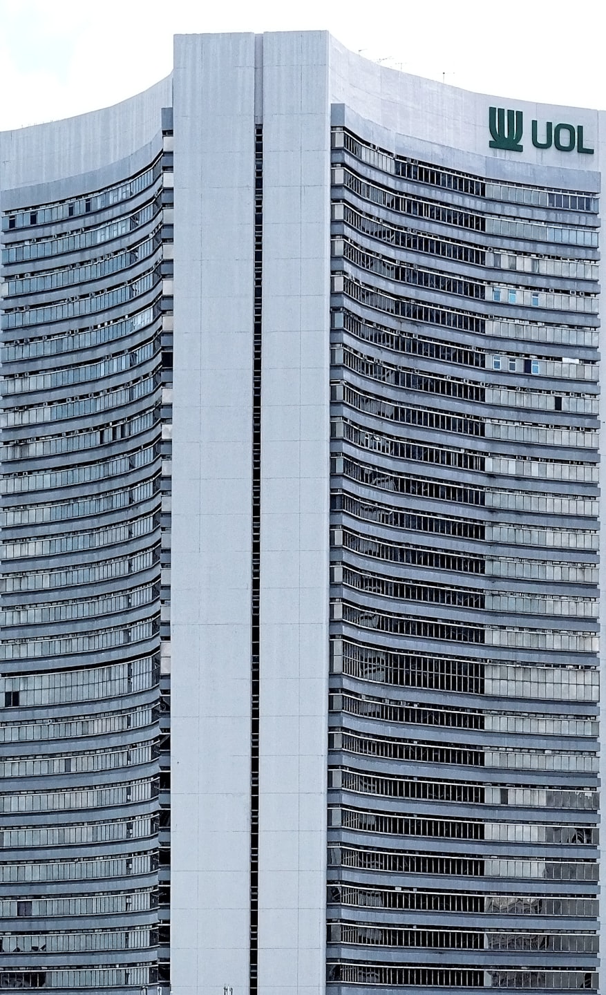 Moderno edificio aziendale con facciata in cemento grigio e finestre scure.