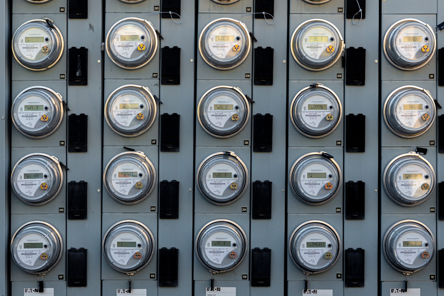 File di contatori elettrici montati su un pannello industriale.